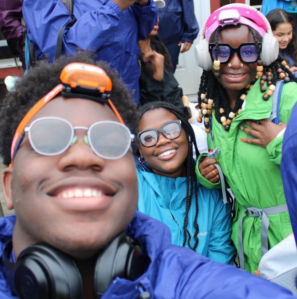 Selfie of three teenagers in rain gear smiling big