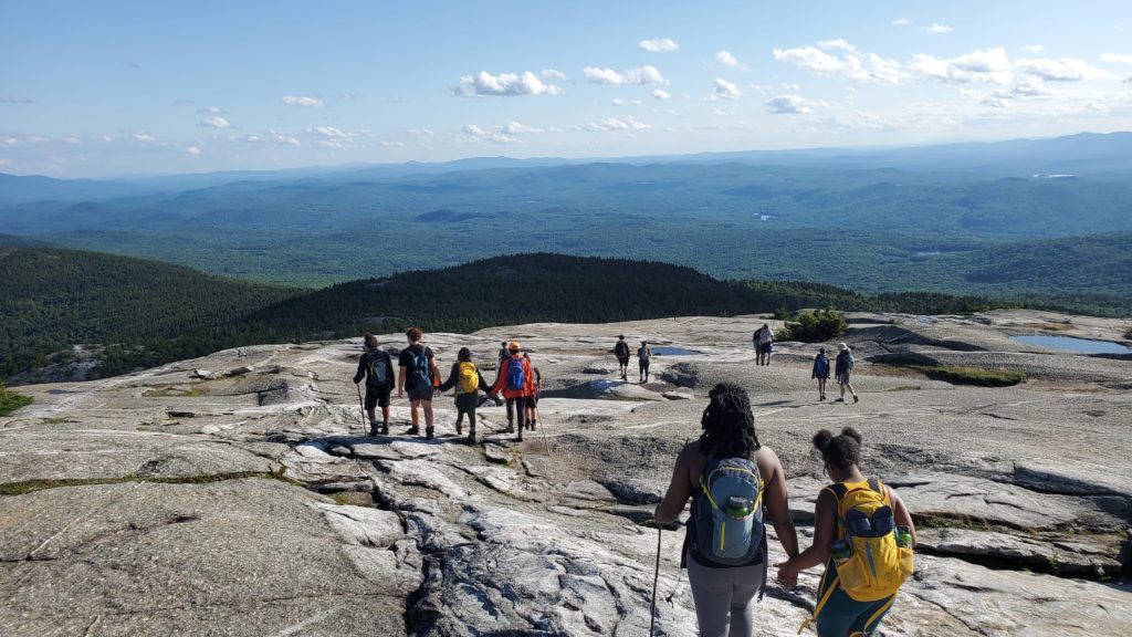 Many people walking on a rocky mountaintop